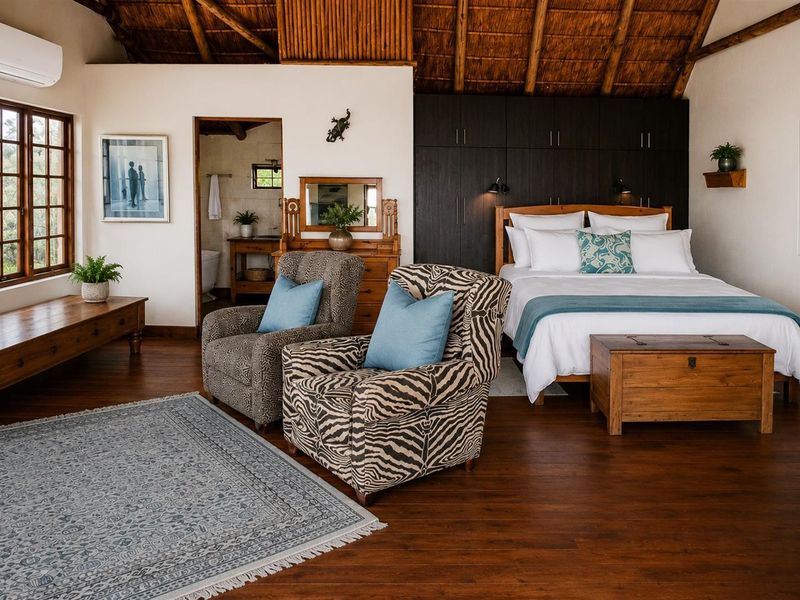 Spacious bedroom featuring high vaulted thatch ceilings with exposed timber rafters, rich hardwood flooring, and extensive built-in cabinetry.