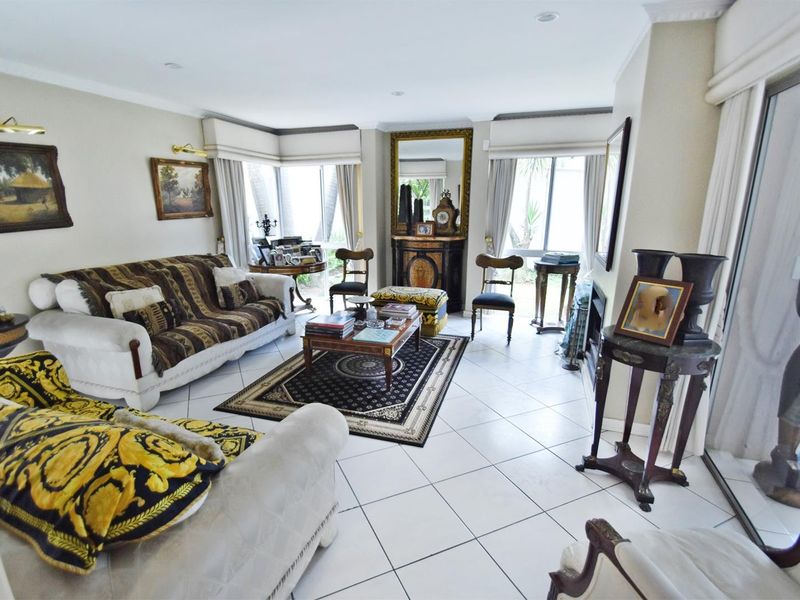 A spacious living room featuring tiled flooring, recessed lighting, and large sliding glass doors that provide ample natural light.