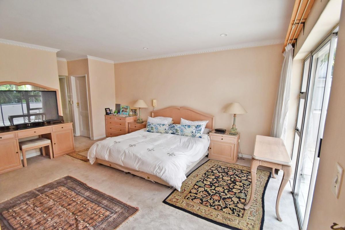 Spacious bedroom featuring neutral wall tones, carpeted flooring, and large sliding glass doors providing access to the exterior.