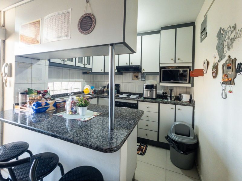 A functional kitchen featuring granite countertops, ample built-in cabinetry, a breakfast bar, and integrated appliances, offering a practical layout for daily use.