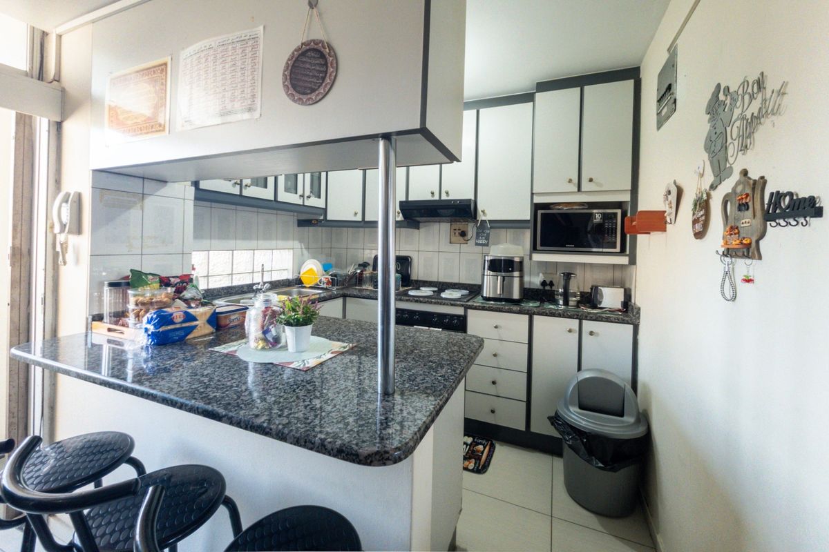 A functional kitchen featuring granite countertops, ample built-in cabinetry, a breakfast bar, and integrated appliances, offering a practical layout for daily use.