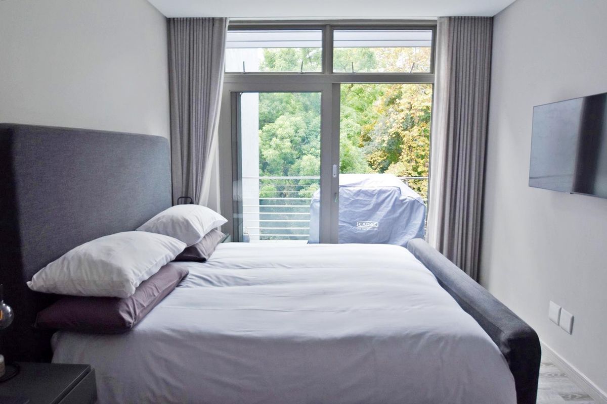 A well-maintained bedroom featuring large sliding glass doors that provide natural light and direct access to a private balcony.
