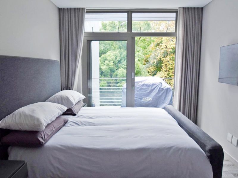A well-maintained bedroom featuring large sliding glass doors that provide natural light and direct access to a private balcony.