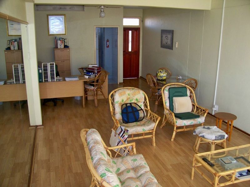 Open plan living area featuring laminate flooring and a ceiling fan, providing a versatile space for lounge and office use.