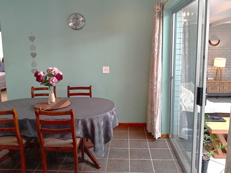 Dining area featuring tiled flooring and a large sliding glass door providing access to the adjacent living space.