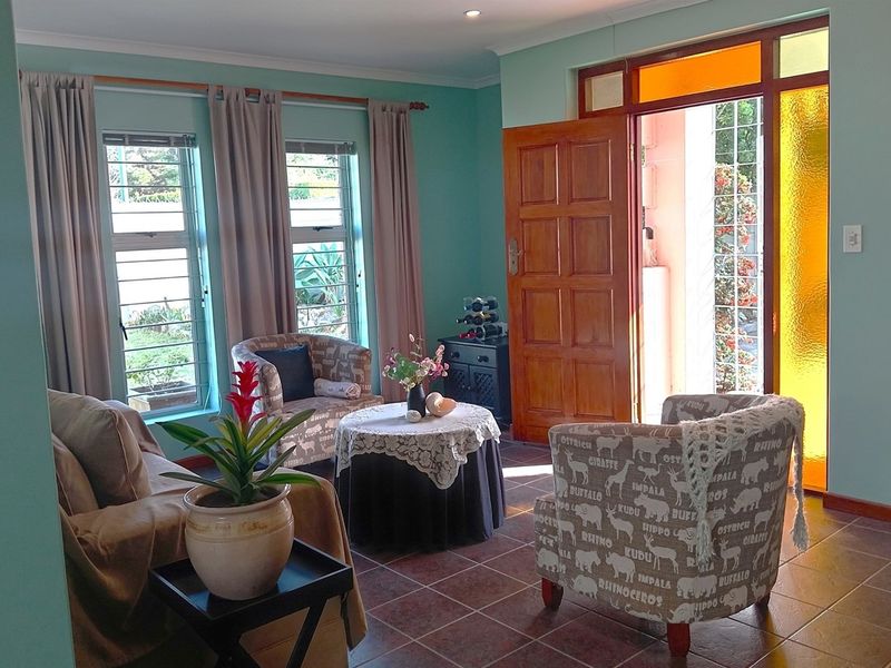 A bright living room featuring tiled flooring, recessed lighting, and direct access to the exterior through a timber door with decorative glass panels.