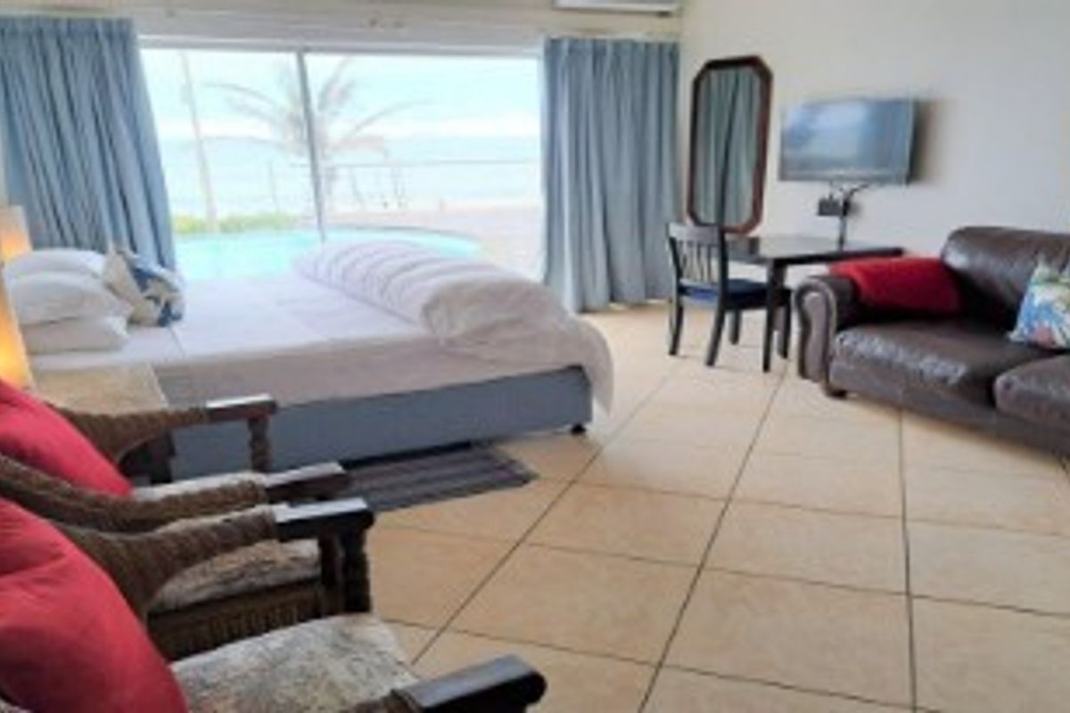 Spacious bedroom featuring tiled flooring, air conditioning, and large sliding glass doors providing direct access to the outdoor pool area.