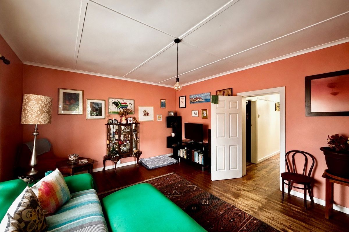 A living room featuring hardwood flooring and a panelled ceiling, providing a warm and traditional atmosphere.