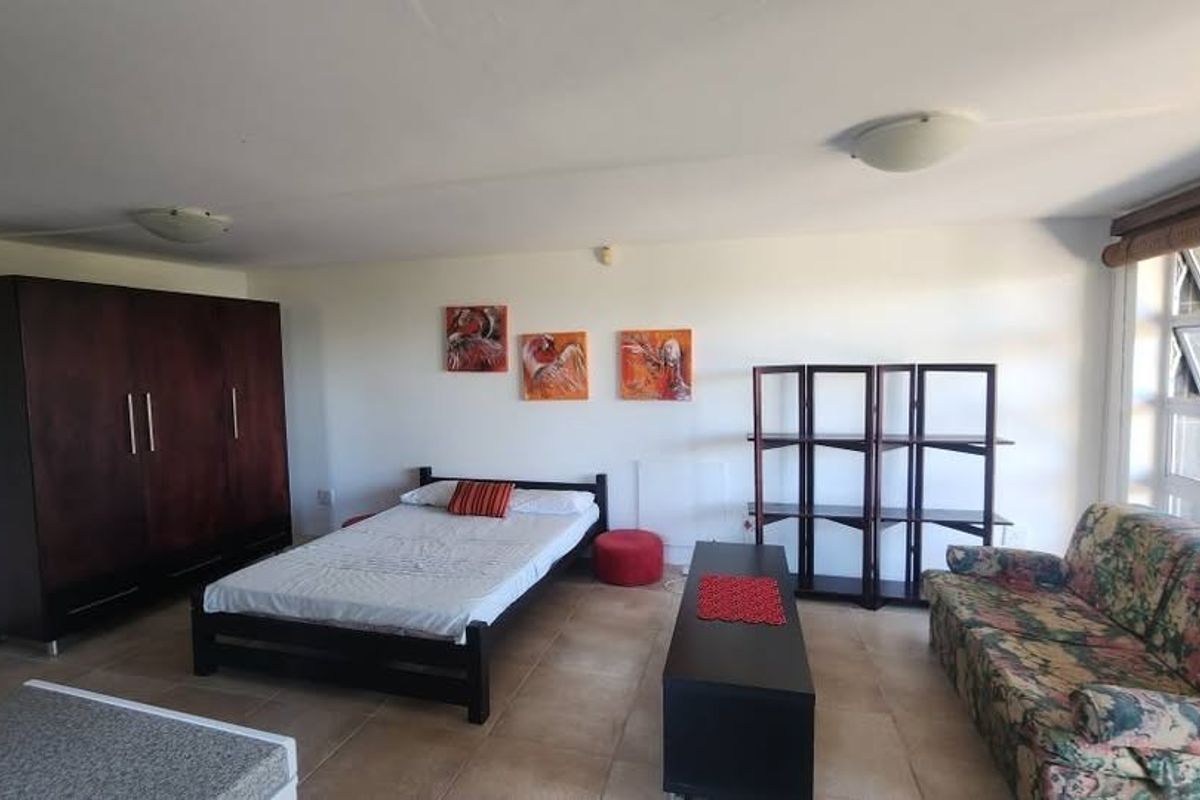 A spacious bedroom featuring tiled flooring, top-hung windows, and dual flush-mount ceiling lights, offering a functional layout with ample natural light.