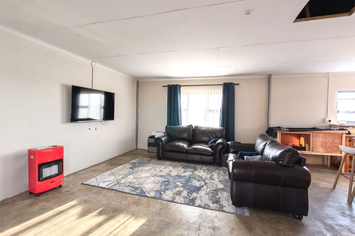 Spacious living area featuring polished concrete floors, recessed lighting, and exposed electrical conduit, offering a blank canvas for interior design updates.