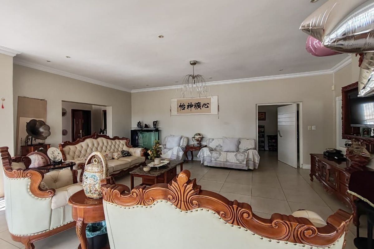 Spacious living room featuring neutral tiled flooring, recessed lighting, and decorative coving, offering a versatile layout for comfortable family living.