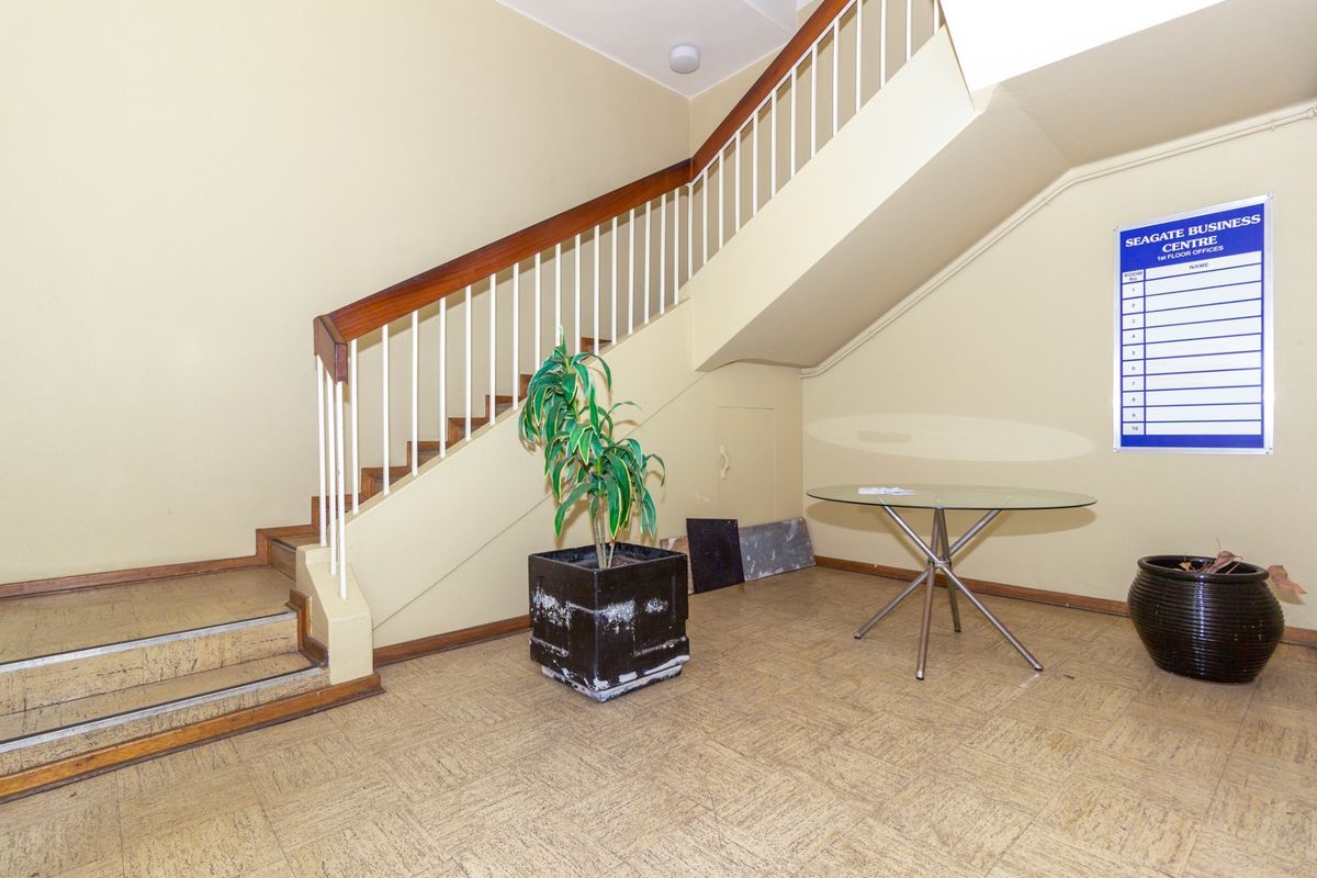 Office building entrance foyer featuring a staircase with a wooden handrail and a directory board for the Seagate Business Centre.