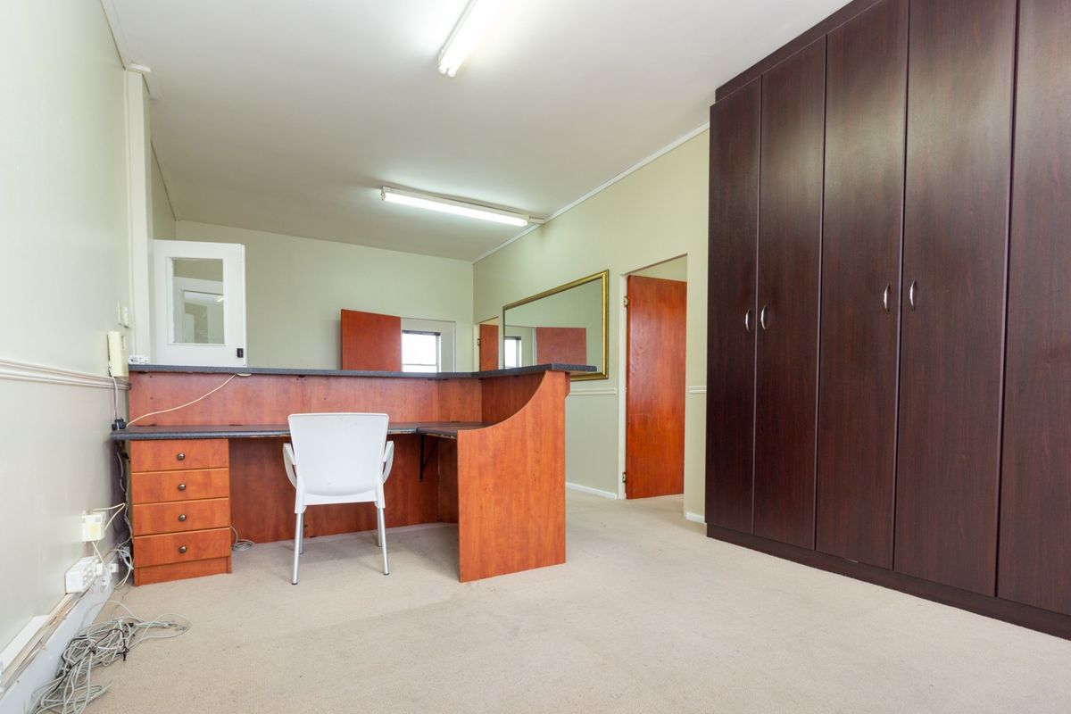 Office space featuring built-in cabinetry, a fitted desk unit, and carpet flooring, offering a functional layout for professional use.