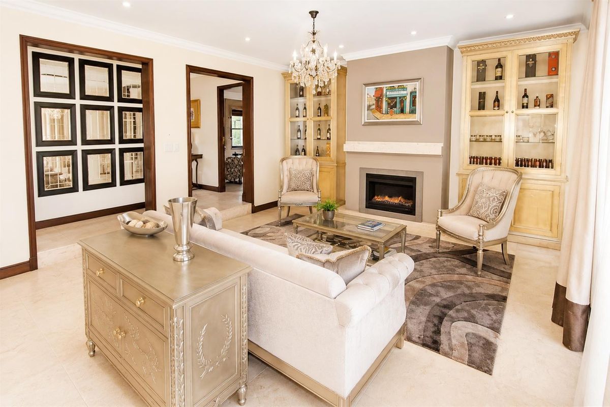 Elegant living room featuring a built-in fireplace, custom cabinetry, recessed lighting, and polished stone flooring.