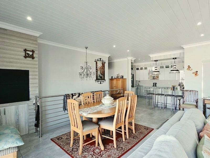 Spacious open-plan living, dining, and kitchen area featuring modern cabinetry, a central island, recessed lighting, and a stylish tongue and groove ceiling.