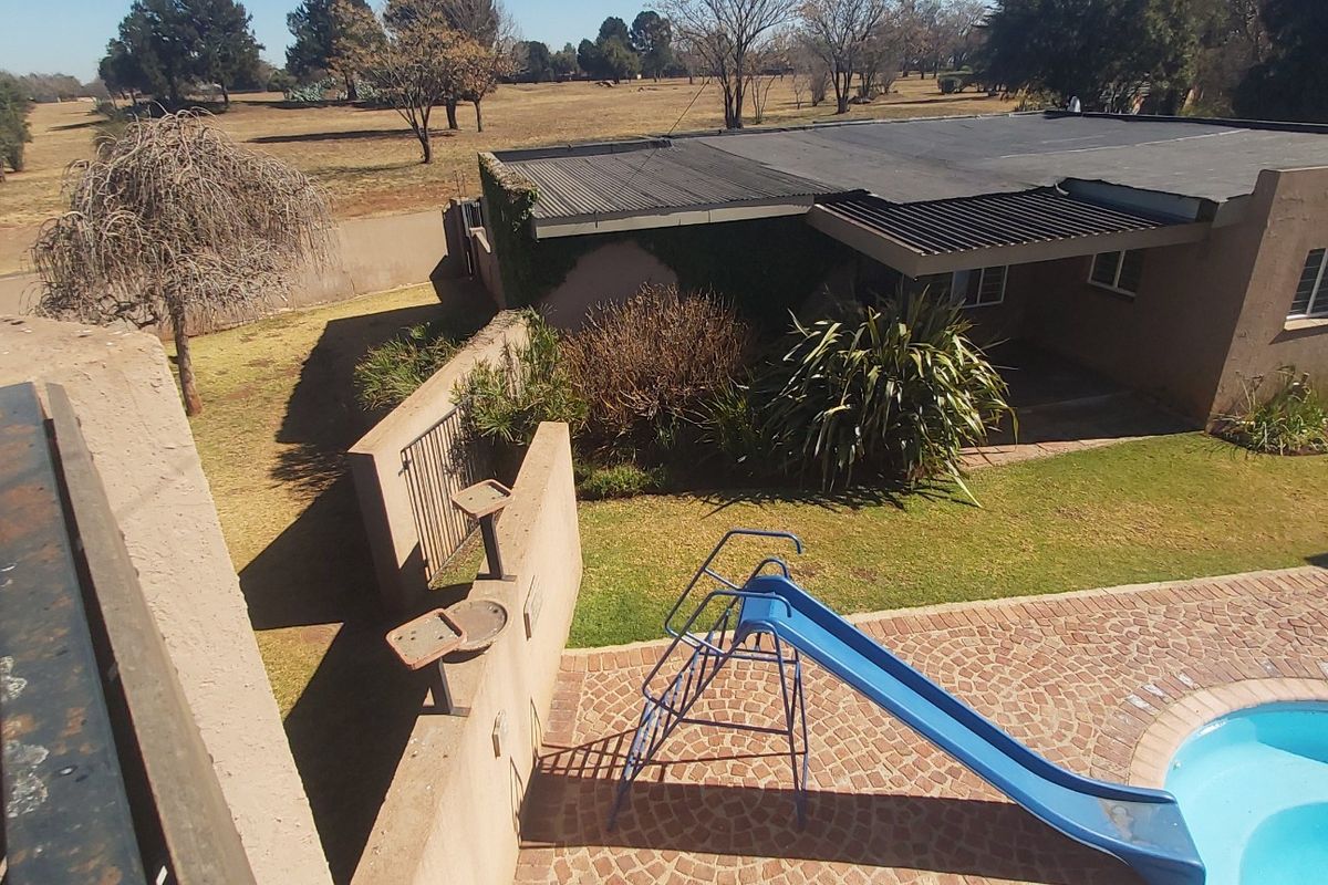 Aerial view of the property featuring a swimming pool, paved patio area, and a rear garden with a boundary wall.