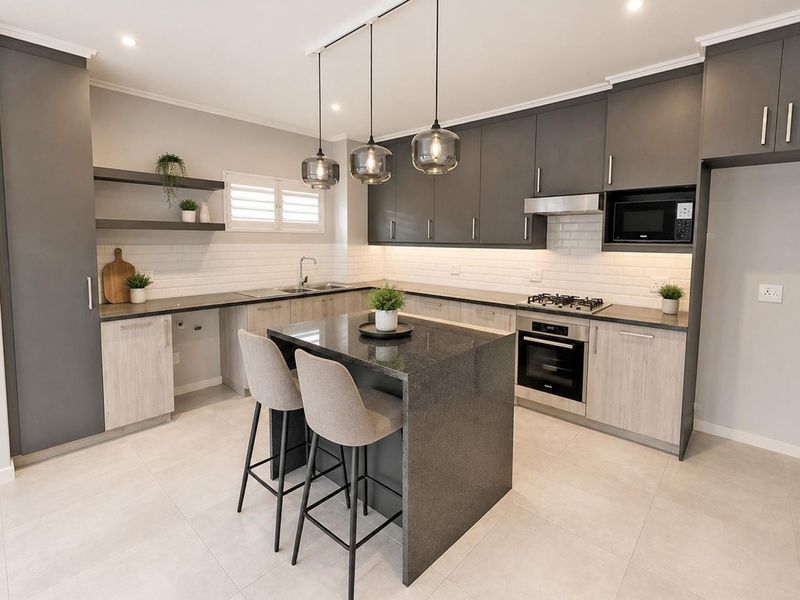 Modern kitchen featuring two-tone cabinetry, stone countertops, a central island, subway tile backsplash, and integrated appliances including a gas hob and oven.