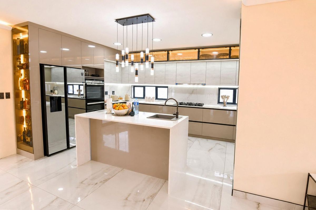 Modern, high-end kitchen featuring a central island, quartz countertops, integrated appliances, sleek cabinetry, and elegant marble-look flooring with sophisticated pendant lighting.