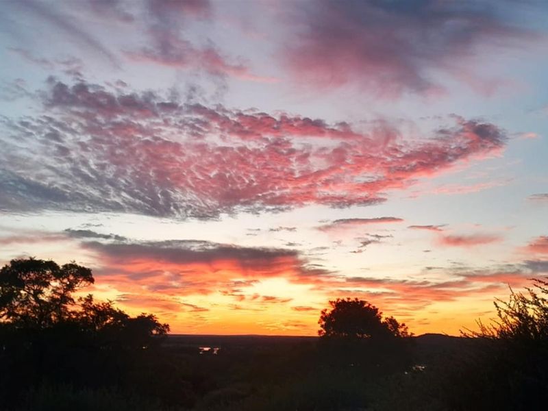 A scenic sunset view overlooking the natural landscape, showcasing the property's elevated position and surrounding environment.