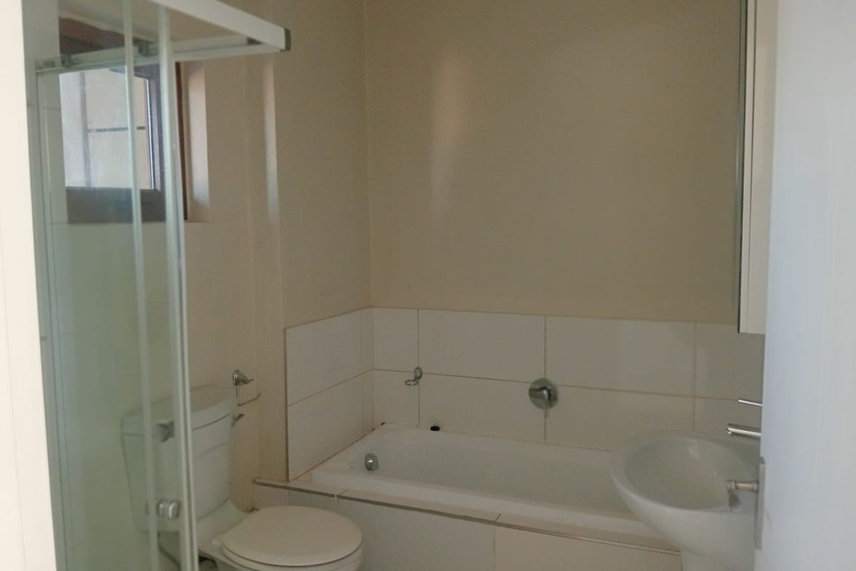 A functional bathroom featuring a bathtub, pedestal basin, toilet, and a separate shower enclosure with tiled splashbacks.