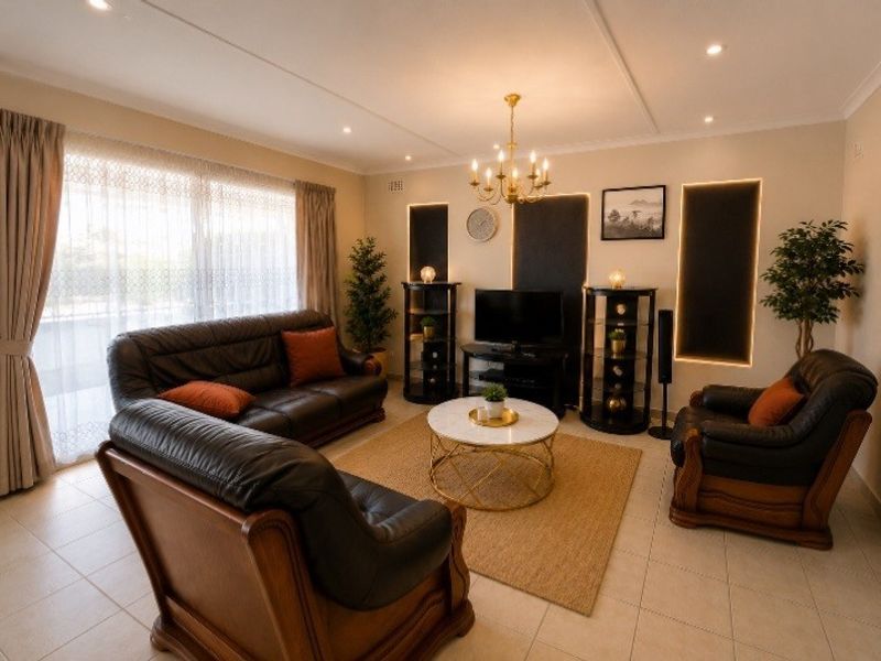 A well-maintained living room featuring tiled flooring, recessed ceiling lighting, and large sliding glass doors that provide ample natural light.