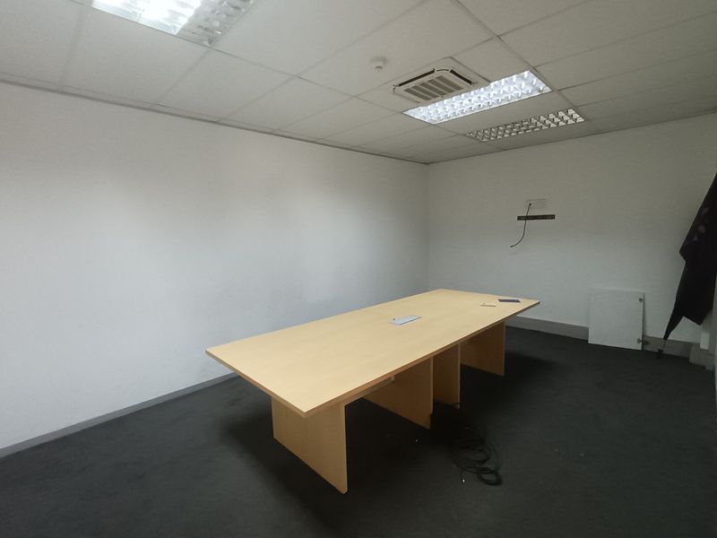 A functional office space featuring a suspended ceiling with recessed lighting, integrated air conditioning, and carpeted flooring.