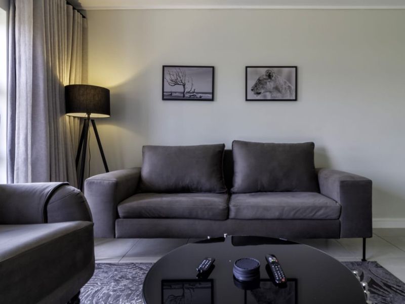 A well-maintained living room featuring neutral tiled flooring and floor-to-ceiling curtain tracks, providing a clean and modern foundation for the space.