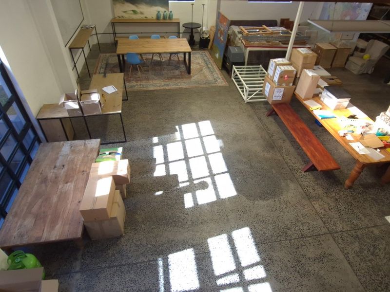Spacious open-plan retail or office area featuring polished concrete floors, high ceilings, and large industrial-style windows providing ample natural light.