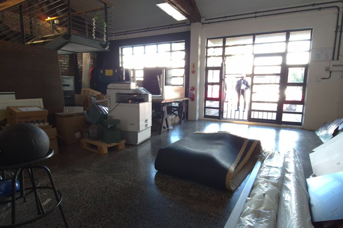 Spacious industrial-style open plan commercial area featuring polished concrete floors, exposed timber beams, and large steel-framed windows providing ample natural light.