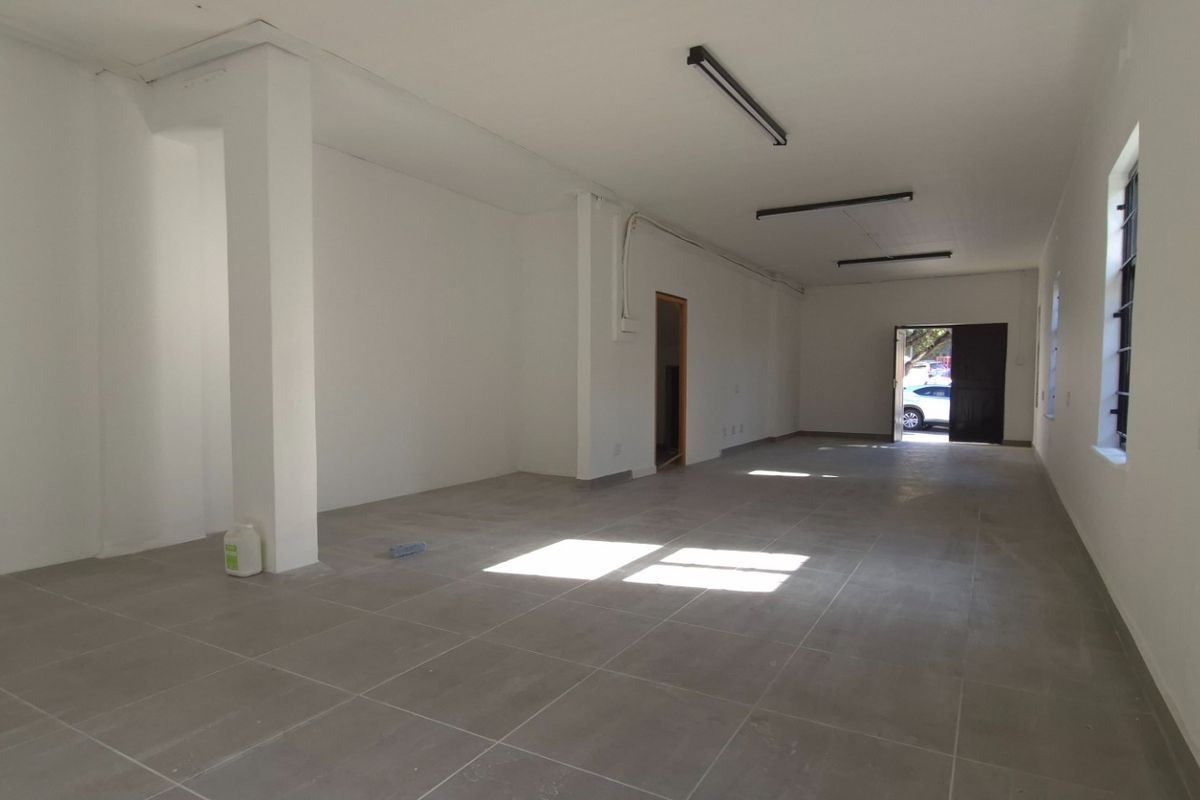 A spacious, vacant open-plan retail area featuring neutral tiled flooring, clean white walls, and functional strip lighting, ready for custom fit-out.