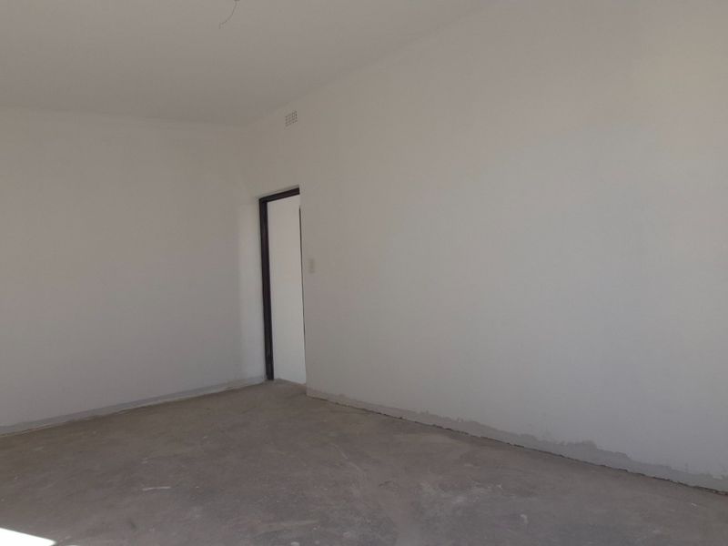 An empty, unfinished interior space with bare concrete flooring and plain white walls, suitable for various retail or commercial fit-out purposes.