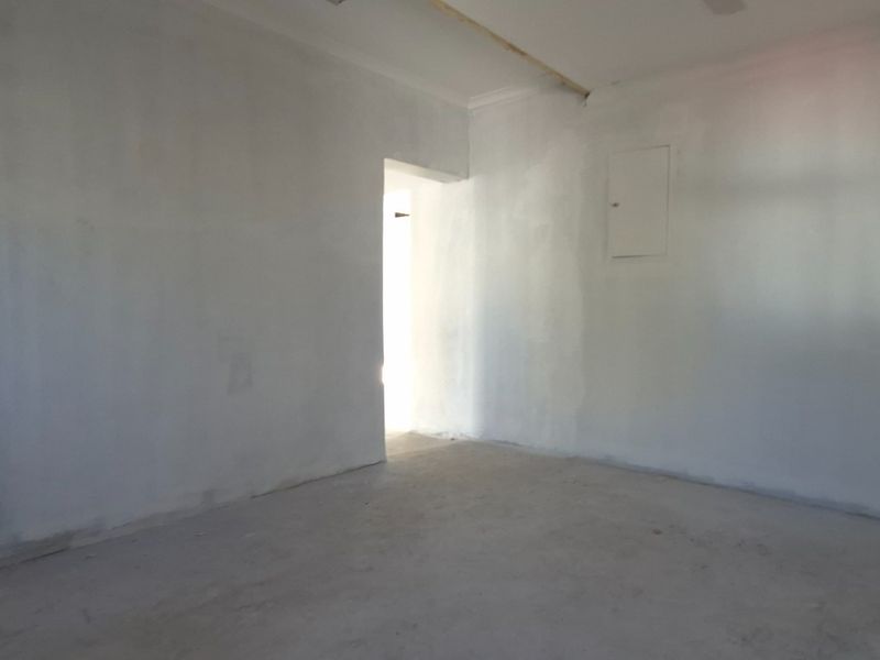 An empty, unfinished interior space with bare walls and exposed flooring, suitable for retail or office fit-out.