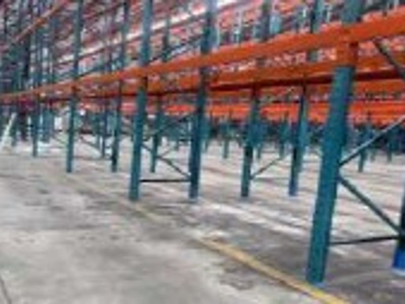 Large industrial warehouse space featuring extensive heavy-duty pallet racking systems and durable concrete flooring, suitable for logistics or storage operations.