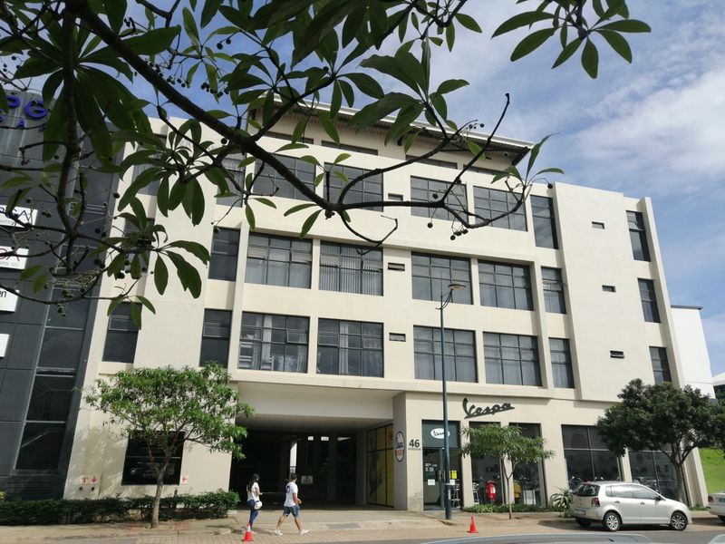 Front elevation of a multi-story apartment building featuring large windows and ground-level commercial access.