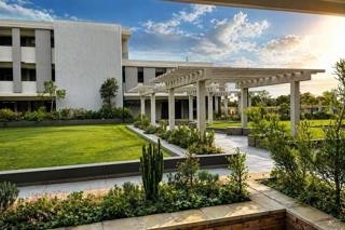 A well-maintained communal garden area featuring a modern pergola, paved pathways, and manicured lawns set against the apartment building facade.