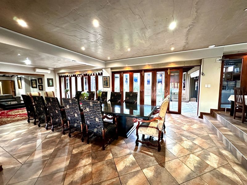 Spacious dining room featuring tiled flooring, textured ceiling, and timber folding doors providing seamless access to the outdoor patio area.