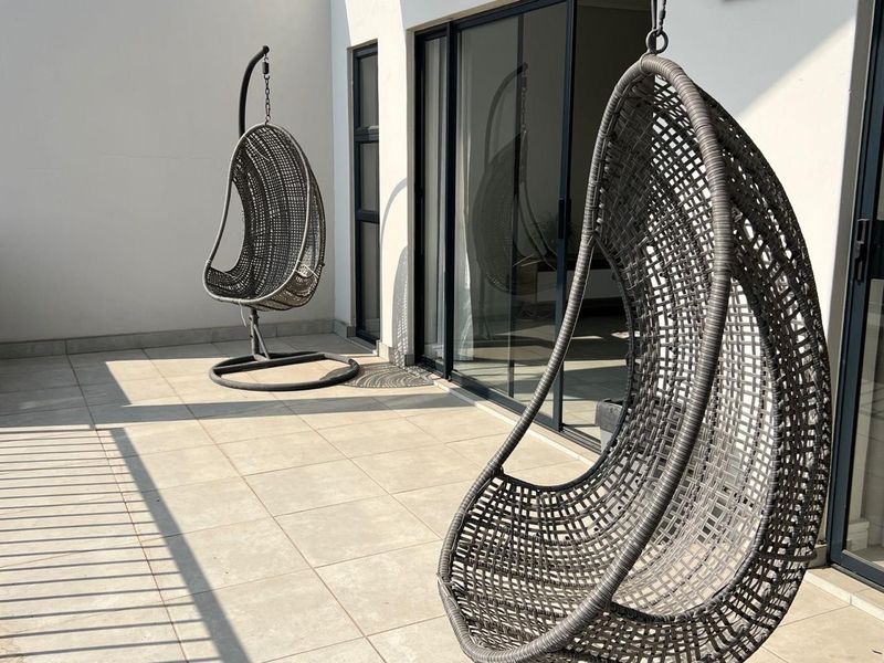 A spacious, tiled balcony featuring modern sliding glass doors and a metal balustrade, offering a clean and well-maintained outdoor living space.