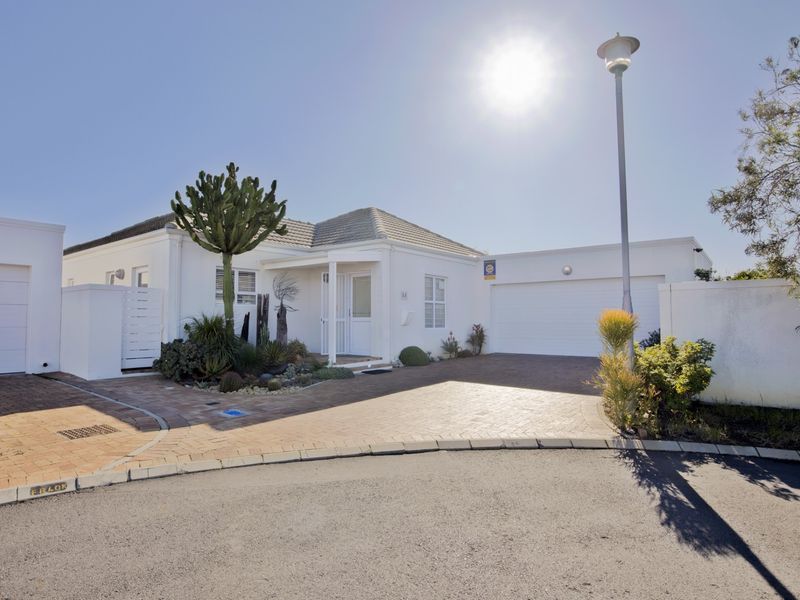 Front elevation of a well-maintained house featuring a paved driveway, double garage, single garage, and established low-maintenance garden.