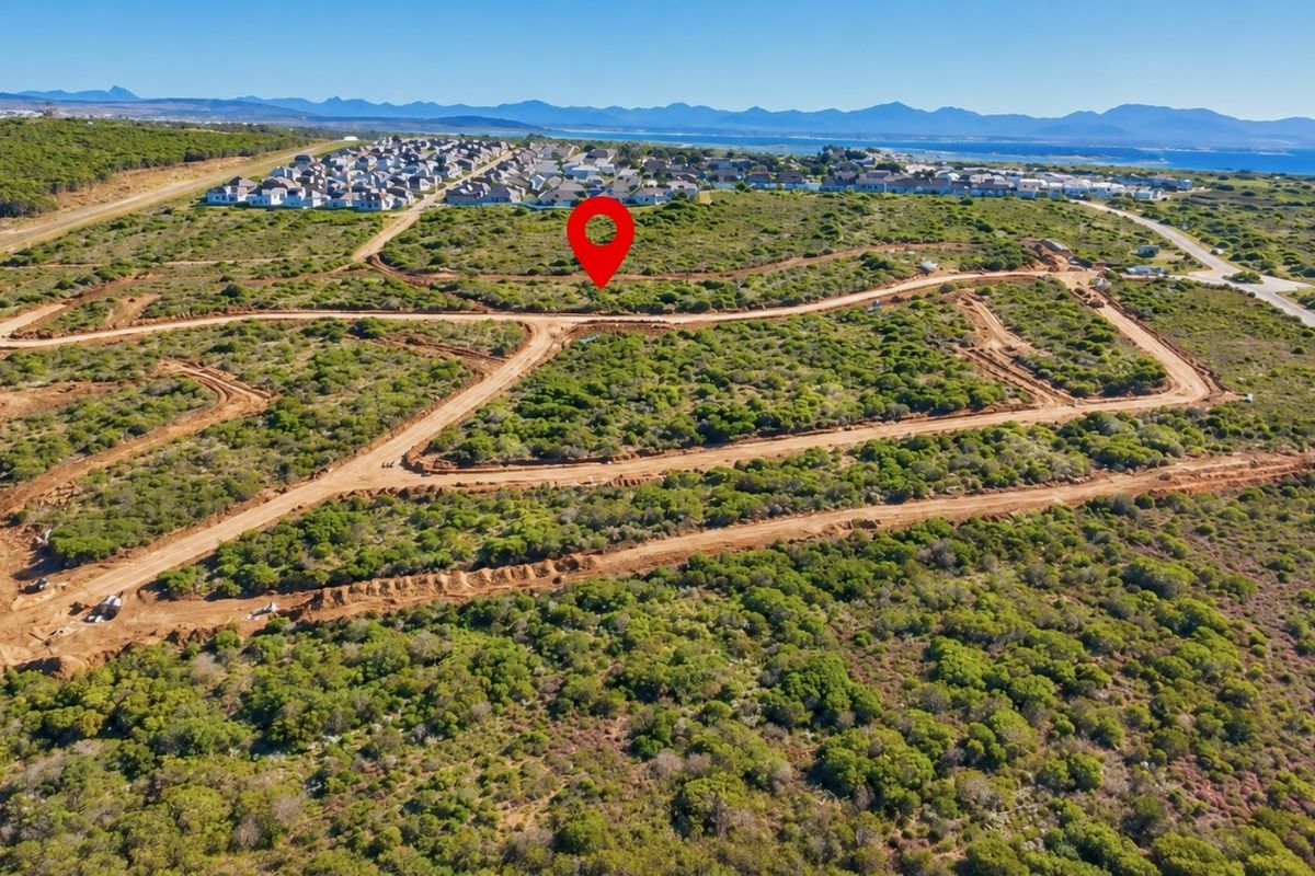 Aerial view of a vacant residential land plot featuring natural vegetation and established dirt access roads within a developing estate.