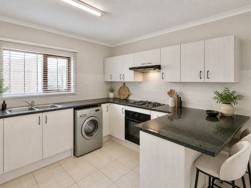 A well-maintained kitchen featuring light wood-grain cabinetry, dark granite countertops, integrated gas hob, oven, and extractor fan with tiled flooring and backsplash.
