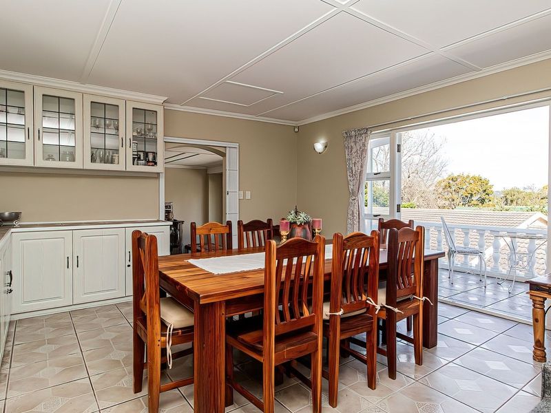 Open plan dining area featuring built-in cabinetry, wine storage, and direct access to a balcony through double glass doors.