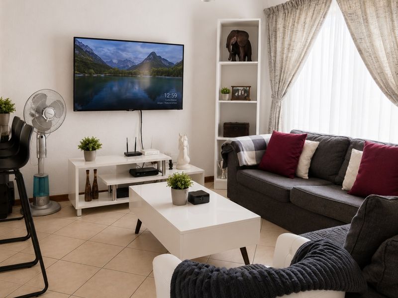 A comfortable living room featuring tiled flooring and a built-in shelving unit, providing a functional and inviting space for relaxation.