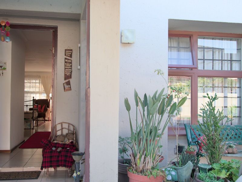 Entrance area featuring tiled flooring and access to the interior, with exterior window security bars and a small covered porch area.
