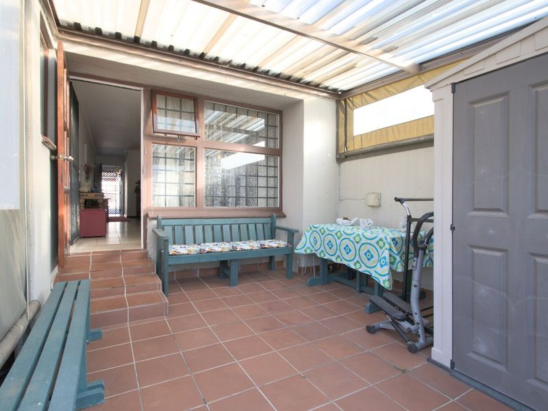 Covered patio area featuring tiled flooring and a translucent roof, providing a sheltered outdoor space with direct access to the home interior.