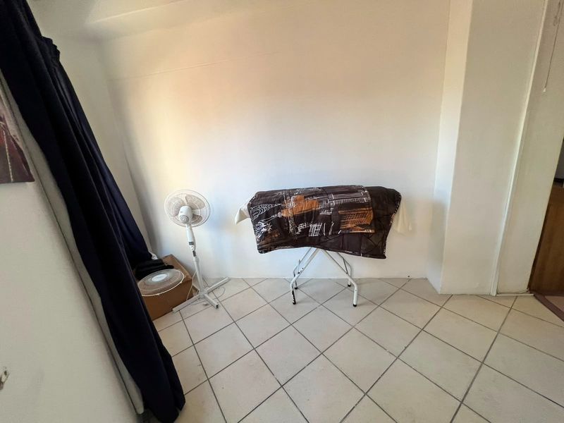 A simple, tiled bedroom space with plain white walls, suitable for a variety of interior design styles.