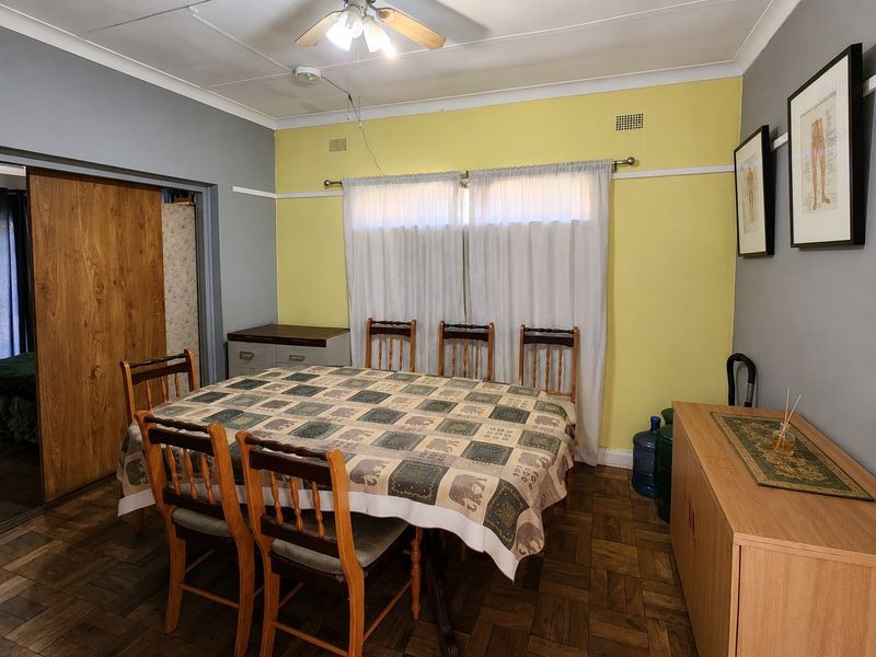 Dining room featuring parquet flooring, coved cornicing, and a ceiling fan, with a sliding door leading to an adjacent room.
