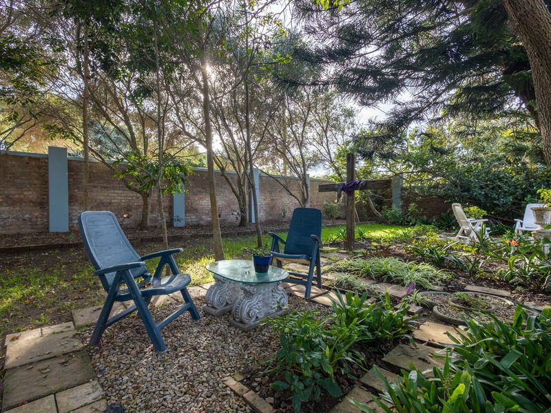 A private garden area featuring established trees, mature landscaping, and a brick boundary wall providing a secluded outdoor space.