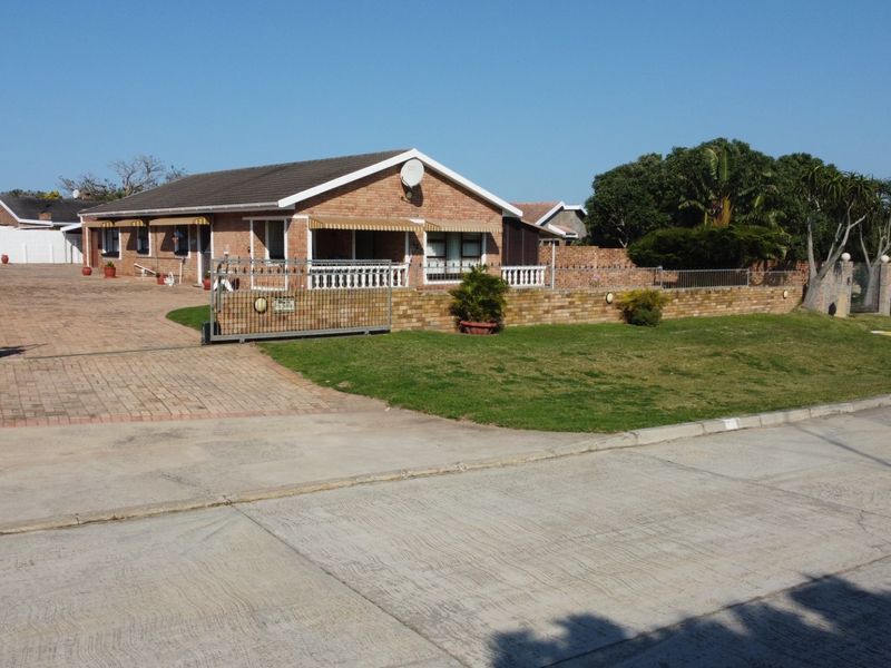 A single-story brick house featuring a paved driveway, secure sliding gate, and a well-maintained front lawn with perimeter brick walling.