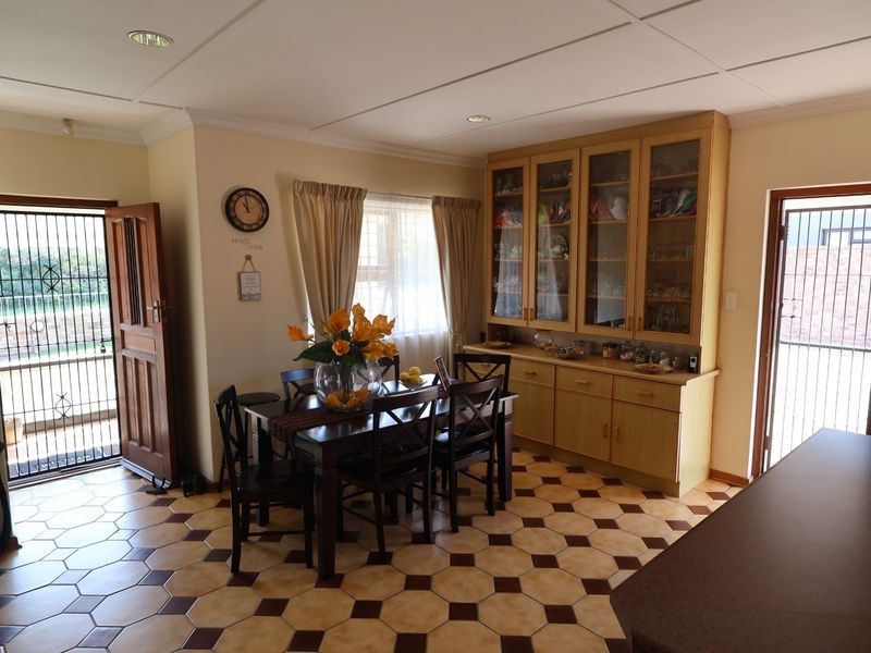 Dining area featuring built-in wooden cabinetry, tiled flooring, and direct access to exterior spaces through security doors.