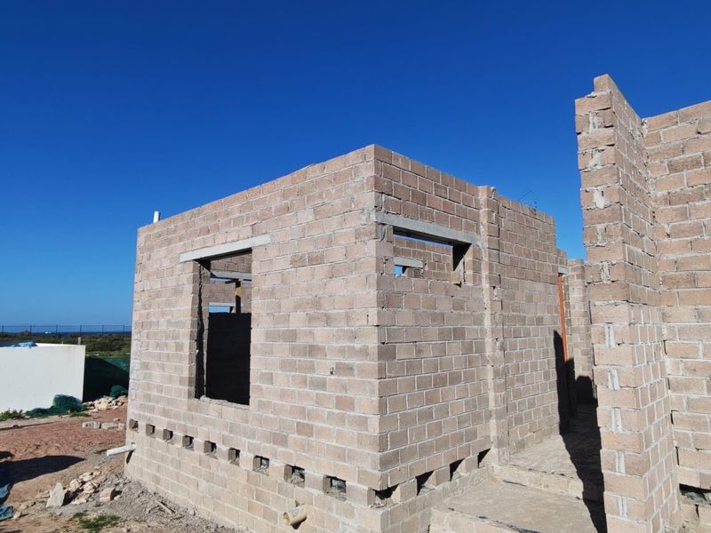 A property under construction featuring exposed concrete block masonry walls and structural lintels, representing the early stages of building development.